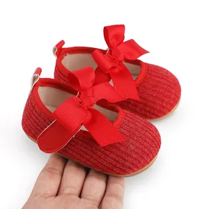 Gros plan détaillé sur des chaussures de fête rouges pour bébé avec grands nœuds