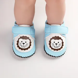 Close-up detail of soft-soled blue baby toddler shoes with cute lion cartoon design