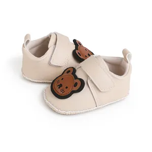 Detailansicht des weichen beigen Materials und des süßen Bärenaufnähers dieser Babyschuhe