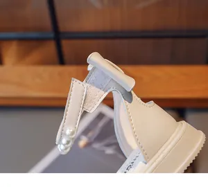Close-up of girl's sandal with elegant bow, pearl strap, and convenient hook-and-loop closure