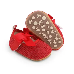 Vue détaillée de chaussures rouges pour bébé avec nœud et semelle antidérapante