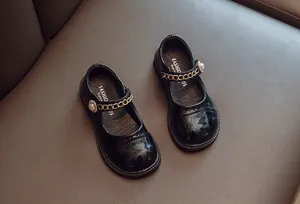 Detailansicht der schwarzen Lackleder Mary Jane Schuhe für Mädchen mit Kette und Perle
