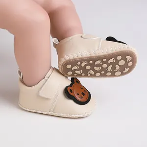Detailansicht von Baby-Lauflernschuhen mit Gummisohle und Bären-Aufnäher
