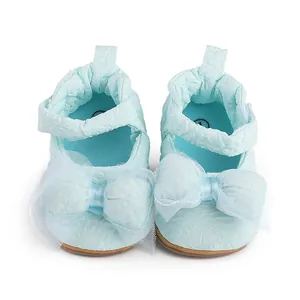 Vue détaillée de chaussures de marche bleues pour bébé avec un grand nœud en tulle doux
