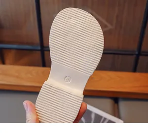 Close-up detail showing the white non-slip rubber sole of girl's summer sandals