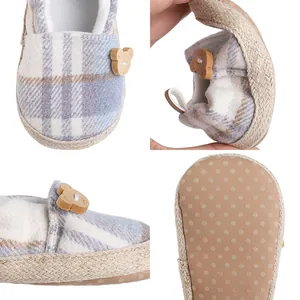 Detail shot of a blue plaid baby shoe featuring a flexible sole and a cute bear button