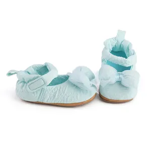 Vue détaillée de chaussures bébé bleu clair avec nœud en maille et texture