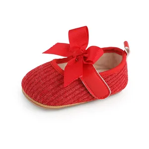 Gros plan détaillé d'une chaussure de fête rouge pour bébé fille avec un grand nœud.