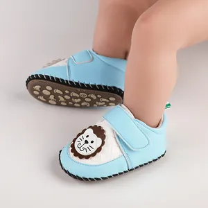 Close-up of blue baby pre-walker shoes with a cute lion patch and velcro strap design