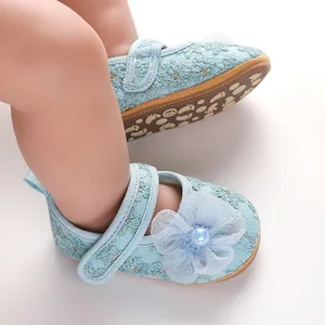 Detail von hellblauen Baby-Prinzessinenschuhen mit Blumenstickerei und Netzblumendekoration