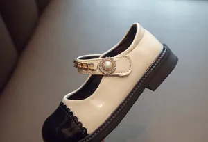 Detailansicht von zweifarbigen Mary Jane Mädchenschuhen mit Perle und Goldkette