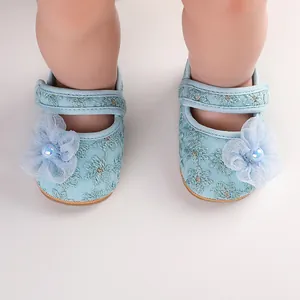 Detailaufnahme hellblauer Baby-Prinzessin-Schuhe mit Spitze und 3D-Blumenverzierung