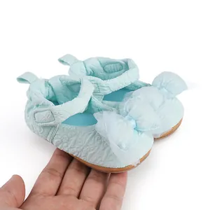 Vue détaillée de chaussures de marche bleues pour bébé avec nœuds en tulle et texture