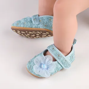 Nahaufnahme der hellblauen Baby-Prinzessinenschuhe mit floraler Stickerei und Perle.