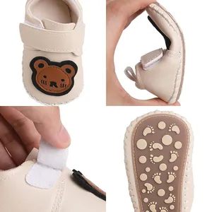 Detailansichten von Baby-Lauflernschuhen mit flexibler Sohle und süßem Bärenmuster.