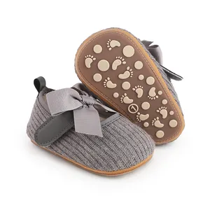 Vue détaillée de chaussures de marche pour bébé en tricot gris avec nœud et semelle antidérapante