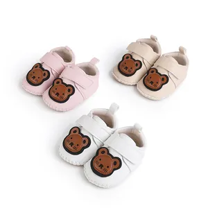 Detailansicht der Baby-Lernlaufschuhe mit Bärenmotiv in den Farben Rosa, Beige und Weiß.