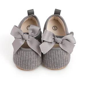 Vue détaillée de chaussures de bébé grises en tricot avec de grands nœuds doux