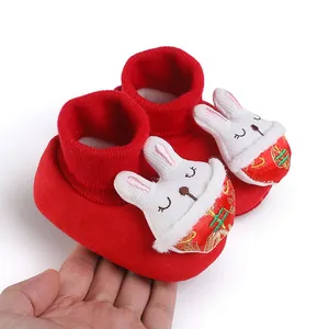 Dettaglio scarpe neonato rosse festive con decoro coniglio 3D e ricami oro