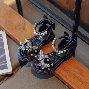 Elegant black girls' sandals featuring pearl straps and rhinestone butterfly accents.