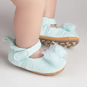 Détail de chaussures de marche bleu clair avec nœuds en tulle pour bébés.