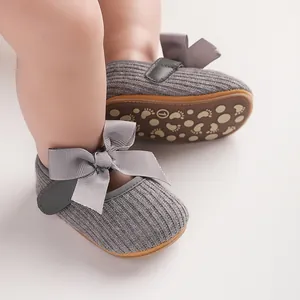 Gros plan de chaussures de bébé grises tricotées avec nœud en satin et semelle antidérapante