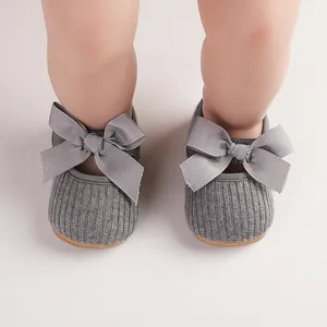 Vue détaillée de chaussures grises pour bébé fille avec de grands nœuds de 3 à 12 mois.