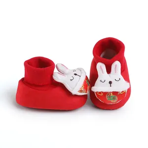 Dettaglio scarpe primi passi rosse neonato con ricamo coniglio e colletto in maglia