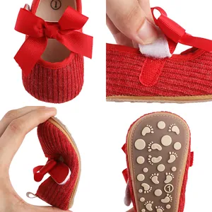 Détail de chaussures de marche bébé rouges avec nœud, semelle souple et velcro.