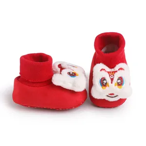 Dettaglio di scarpe primi passi rosse per neonati con simpatica testa di leone in peluche