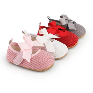 Détail de chaussures à nœud pour bébé fille en rose, blanc, rouge et gris