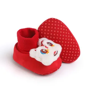 Dettaglio scarpe per neonato rosse con peluche leone festivo e suole antiscivolo