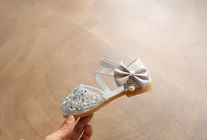 Detailed side profile of silver girl's princess shoes with glitter and satin bow
