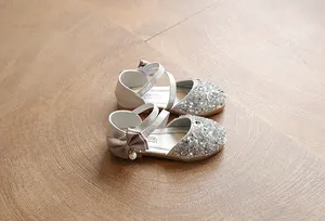 High-definition detail of silver sequin dress shoes for girls with pearl bow ornament