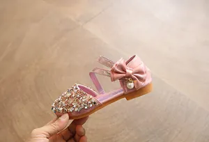 Detailed view of pink girls' sparkling sequin dress shoe featuring bow and pearl charm
