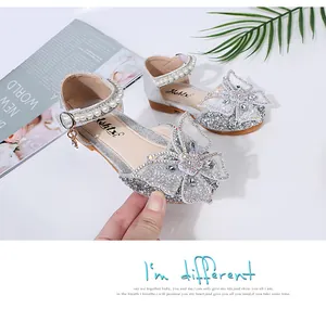 Close-up of girls' silver glitter princess shoes with a butterfly bow detail.