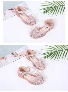 Detailed view of pink glittery girls' princess shoes with pearls and butterfly bow decoration