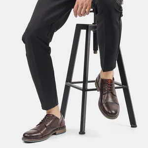 Detailed view of brown burnished men's business casual dress shoes worn with trousers.