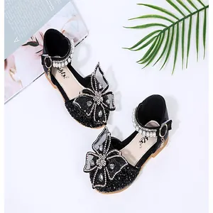 High-detail shot of girls' black glittery princess dress shoes with bow and pearls