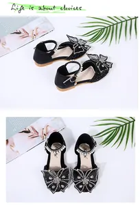 Detailed view of girls black sparkling princess shoes with rhinestone butterfly and pearls