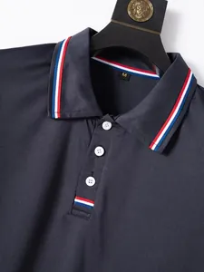 Macro detail of navy blue men's polo shirt featuring striped collar and white buttons