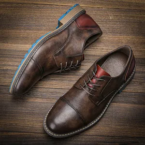 Detailed overhead view of brown textured leather men's dress shoes with stylish blue soles.