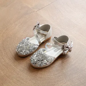 Elegant silver sequin children's flats with crossover straps and a side bow detail