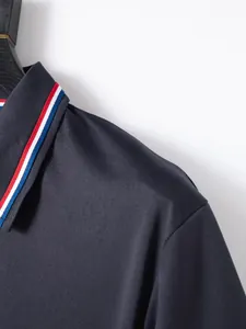 Close-up of navy polo shirt collar with red, white and blue striped ribbon detail