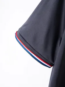 Close-up of men's polo shirt sleeve featuring red, white, and blue striped cuff detail.