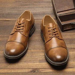 Detail shot of brown leather business dress shoes with contrast stitching on wood