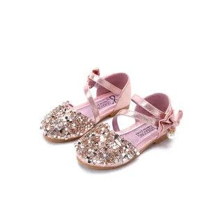 Pink sequined girls' dress shoes with criss-cross straps and decorative heel bows