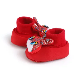 Dettaglio scarpe primi passi rosse per neonato con decorazione a coniglio ricamato