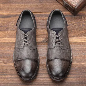 Top view of men's distressed leather dress shoes on a rustic wooden background