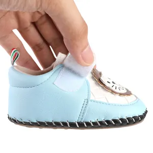 Detailed close-up showing the velcro closure and lion patch on a blue baby pre-walker shoe